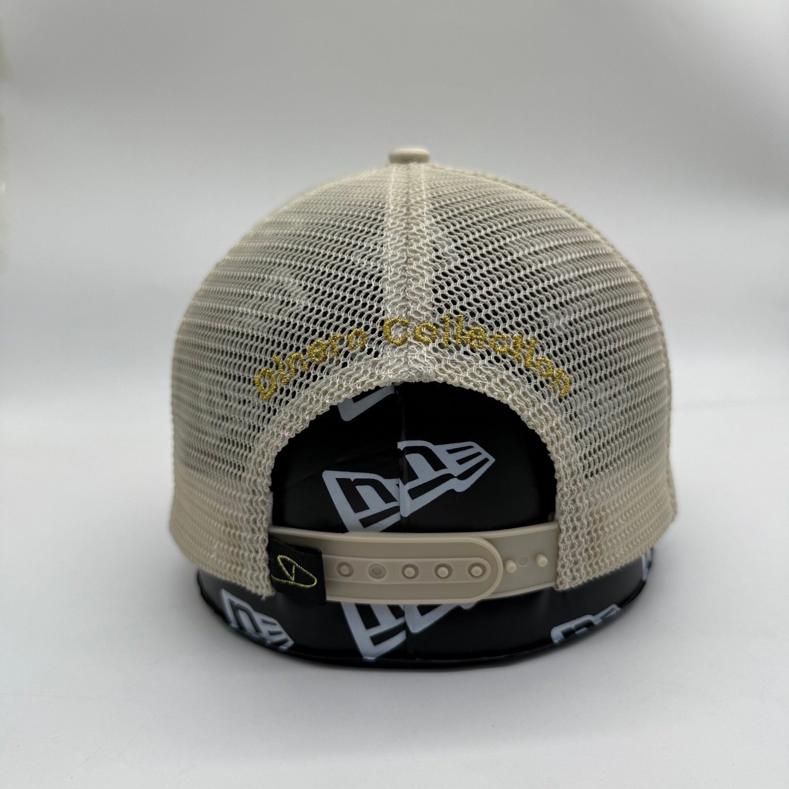 Ivory stone Dinero trucker cap back with gold Dinero Collection arch