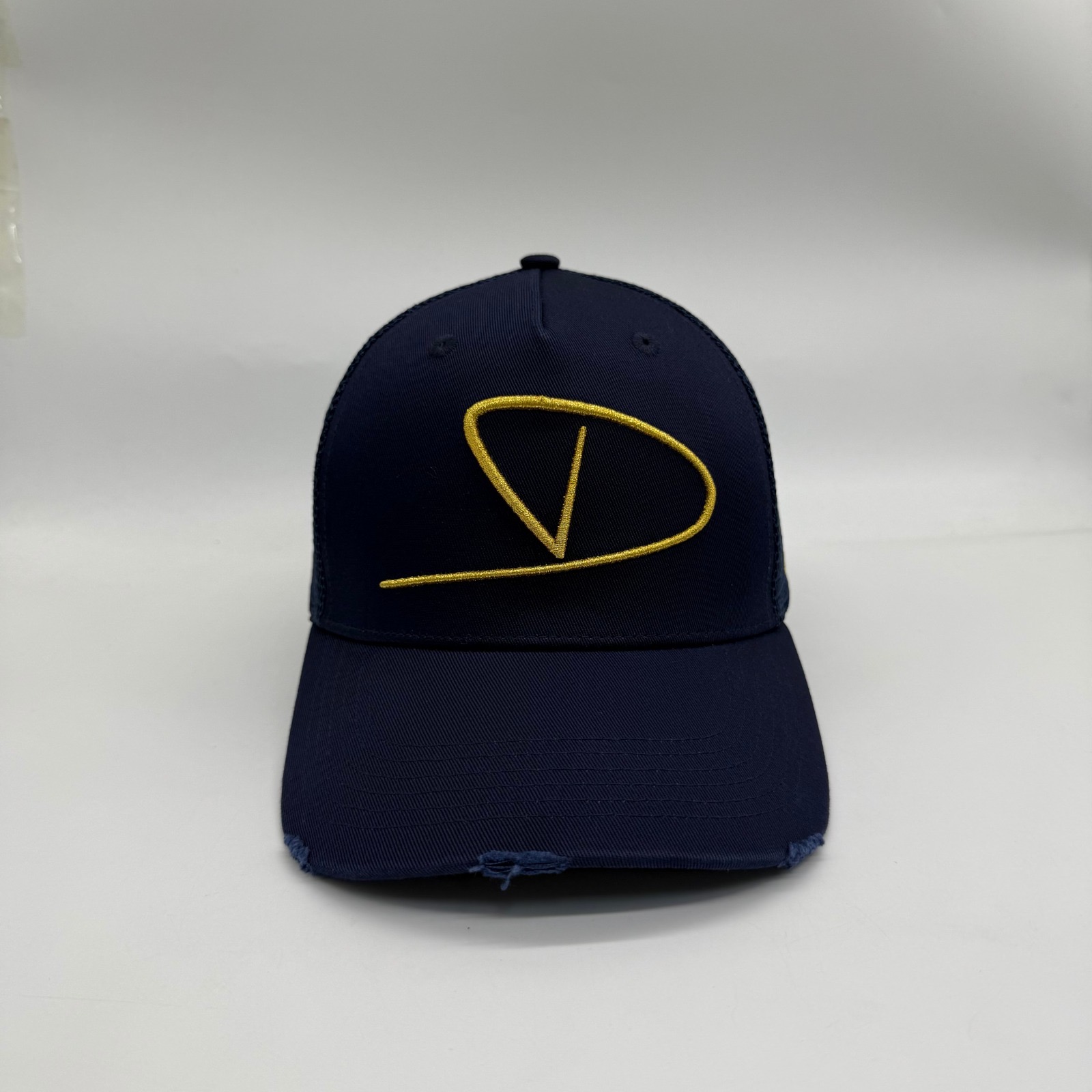 Midnight navy Dinero trucker cap front with gold monogram